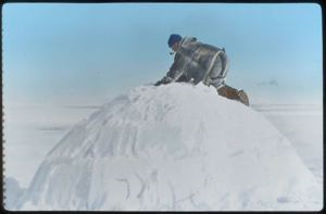 Image of Eskimo on top of a snow house
